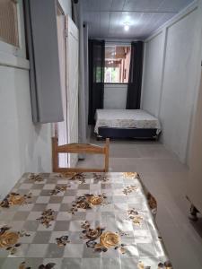 een kamer met een bed, een tafel en een stoel bij Kitinete Quarto para casal in Matinhos