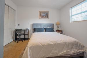 a bedroom with a large bed and a desk at Stylish & Quiet 3BD Sleeps 8 Near Stadium & Downtown in Jacksonville