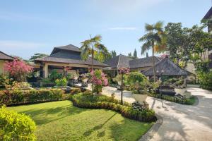 a resort with a garden with flowers and trees at Novotel Bali Nusa Dua in Nusa Dua