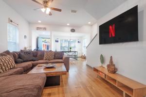 a living room with a couch and a tv on a wall at Stylish & Quiet 3BD Sleeps 8 Near Stadium & Downtown in Jacksonville