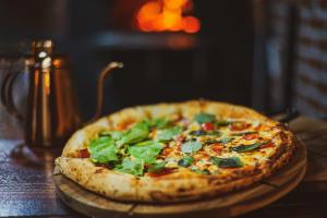 a pizza sitting on top of a wooden table at Emirates Hotel & Suites in Santana do Livramento