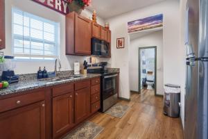 a kitchen with wooden cabinets and a sink and a refrigerator at Stylish & Quiet 3BD Sleeps 8 Near Stadium & Downtown in Jacksonville +8 photos