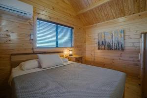 a bedroom with a bed in a wooden cabin at Angel Fire RV Resort in Angel Fire