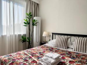 a bedroom with a bed with a floral bedspread at 上海Zighouse人民广场店 People's Square Branch, Shanghai in Shanghai