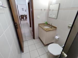 a bathroom with a toilet and a sink and a mirror at Espaço da Paz e Serenidade in Praia Grande +69 photos