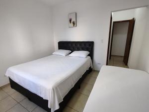a bedroom with two beds and a mirror at Espaço da Paz e Serenidade in Praia Grande