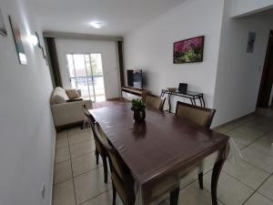 a living room with a wooden table and chairs at Espaço da Paz e Serenidade in Praia Grande