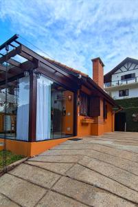 a house with an orange at Chalés Leopoldo em Monte Verde in Monte Verde