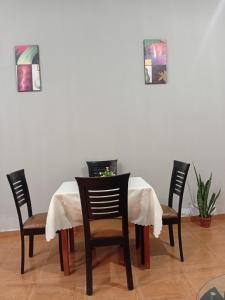 een eettafel met stoelen en een wit tafelkleed bij Departamento in Ilo