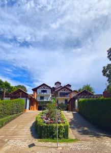 a row of houses with flowers in a driveway at Chalés Leopoldo em Monte Verde in Monte Verde