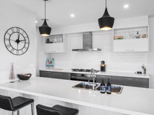 een witte keuken met een wastafel en een klok bij Dan's Rise in Mansfield