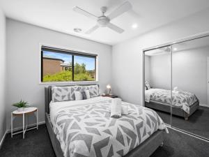 een witte slaapkamer met een bed en een spiegel bij Dan's Rise in Mansfield