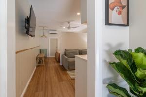 a hallway with a living room and a couch at Hibiscus Cottage in Ballina