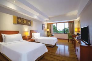 a hotel room with two beds and a flat screen tv at ARTOTEL Gelora Senayan Jakarta in Jakarta