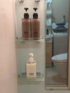 La salle de bains est pourvue d'une bouteille de savon et d'un miroir. dans l'établissement Mori de house in kobe 1, à Kobe