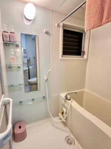 une salle de bain avec une baignoire et un miroir dans l'établissement Mori de house in kobe 1, à Kobe 20 autres photos