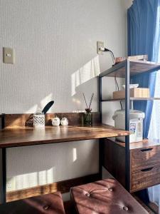 un bureau dans une pièce avec une lampe et deux tabourets dans l'établissement Mori de house in kobe 1, à Kobe