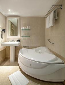 a bathroom with a large tub and a sink at ARTOTEL Gelora Senayan Jakarta in Jakarta