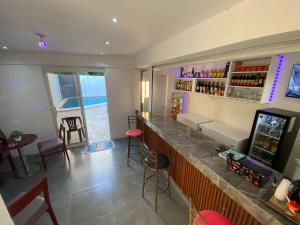 eine Bar in einem Restaurant mit einer Theke und Stühlen in der Unterkunft Hostal y Piscina in La Romana