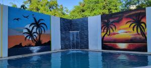 a swimming pool with paintings on the walls at Hostal y Piscina in La Romana