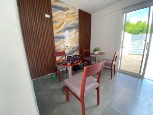 ein Esszimmer mit Stühlen, einem Tisch und einem Fenster in der Unterkunft Hostal y Piscina in La Romana