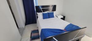 ein Schlafzimmer mit einem Bett mit blauen Laken und blauen Kissen in der Unterkunft Hostal y Piscina in La Romana + 1 Foto