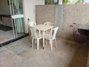 een witte tafel en stoelen in een kamer bij Kitnet das férias in Pontal do Paraná