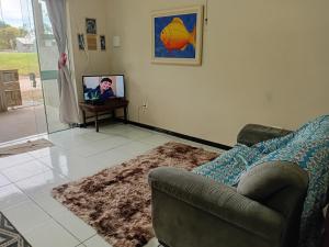een woonkamer met een bank en een tv bij Kitnet das férias in Pontal do Paraná