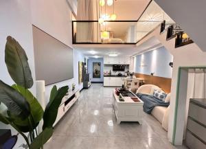 a living room with a couch and a kitchen at Qixin Homestay in Changsha