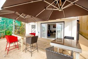 een terras met een tafel, stoelen en een parasol bij La Suerte Villa in Boracay