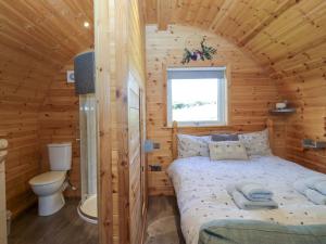 una camera da letto con un letto in una cabina di legno di Cherry a Ulverston Altre 29 foto