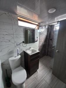 een badkamer met een toilet, een wastafel en een douche bij Hotel Atheron suite La Magia de Zipaquirá in Zipaquirá