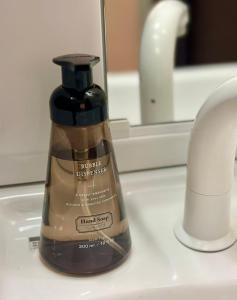 - une bouteille de liquide vaisselle assise sur un lavabo dans l'établissement Mori de house in kobe 1, à Kobe
