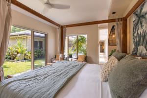 a bedroom with a large bed with a large window at Escapades @ Palm Cove in Palm Cove +38 photos