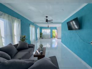 een woonkamer met een bank en een blauwe muur bij Estancia Sofia in Puerto Escondido