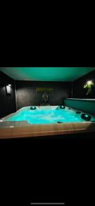 La salle de bains est pourvue d'une baignoire avec de l'eau bleue. dans l'établissement Le côte d opale bohème plage, à Calais