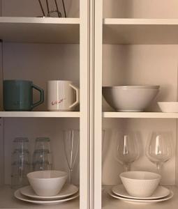 a cabinet filled with bowls and plates and wine glasses at Healing House in Seoul