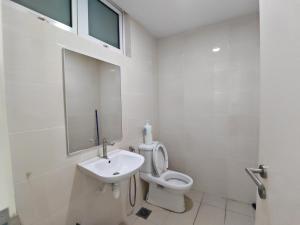 a white bathroom with a toilet and a sink at De Centrum Residences in Kajang