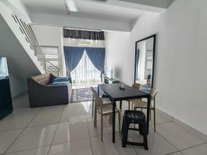 a dining room with a table and chairs and a couch at De Centrum Residences in Kajang +7 photos