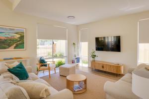 a living room with white furniture and a flat screen tv at Isla Escape Pet Friendly Dunsborough in Dunsborough
