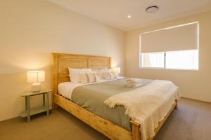 a bedroom with a large bed and a window at Isla Escape Pet Friendly Dunsborough in Dunsborough
