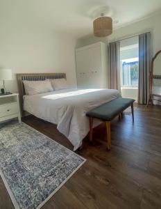 a bedroom with a bed with a bench and a window at Willow in Clifden