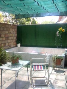 een patio met 2 stoelen, een tafel en een bank bij Mistela Altos de Mendoza - Dpto con Sala de Juegos y Pileta -Zona Residencial a pasos de Ciudad- Viajes- Botella de vino Chocolates o galletitas - Viaje al Aeropuerto gratis - in Godoy Cruz