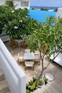 a table and chairs and a tree on a balcony at My Island Home Vanuatu in Eton