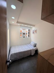 een kleine slaapkamer met een bed en een raam bij Apartamento Moderno en Villeta - Nido de San Miguel in Villeta