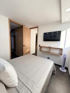 een slaapkamer met een bed en een flatscreen-tv bij Apartamento Moderno en Villeta - Nido de San Miguel in Villeta +26 foto's