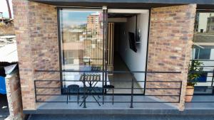 - un balcon avec deux chaises dans un bâtiment en briques dans l'établissement Loft Elegante con Vista a la Ciudad, à Sogamoso