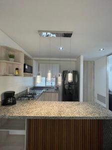 een keuken met een granieten aanrecht en een koelkast bij Exceptional apartment to rest in Cartagena
