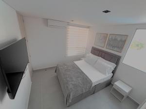 een kleine slaapkamer met een bed en een televisie bij Exceptional apartment to rest in Cartagena +19 foto's