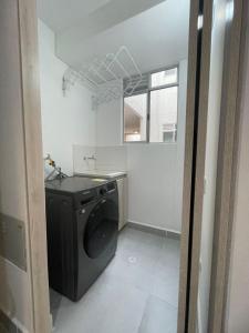 een wasruimte met een wasmachine en een raam bij Exceptional apartment to rest in Cartagena